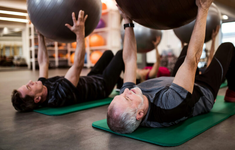 Senior at the gym with a personal trainer