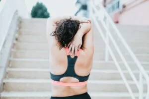 Sore muscles after workout, a woman reaching for her back