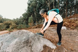 Ankle mobility exercises old senior woman tying her shoes